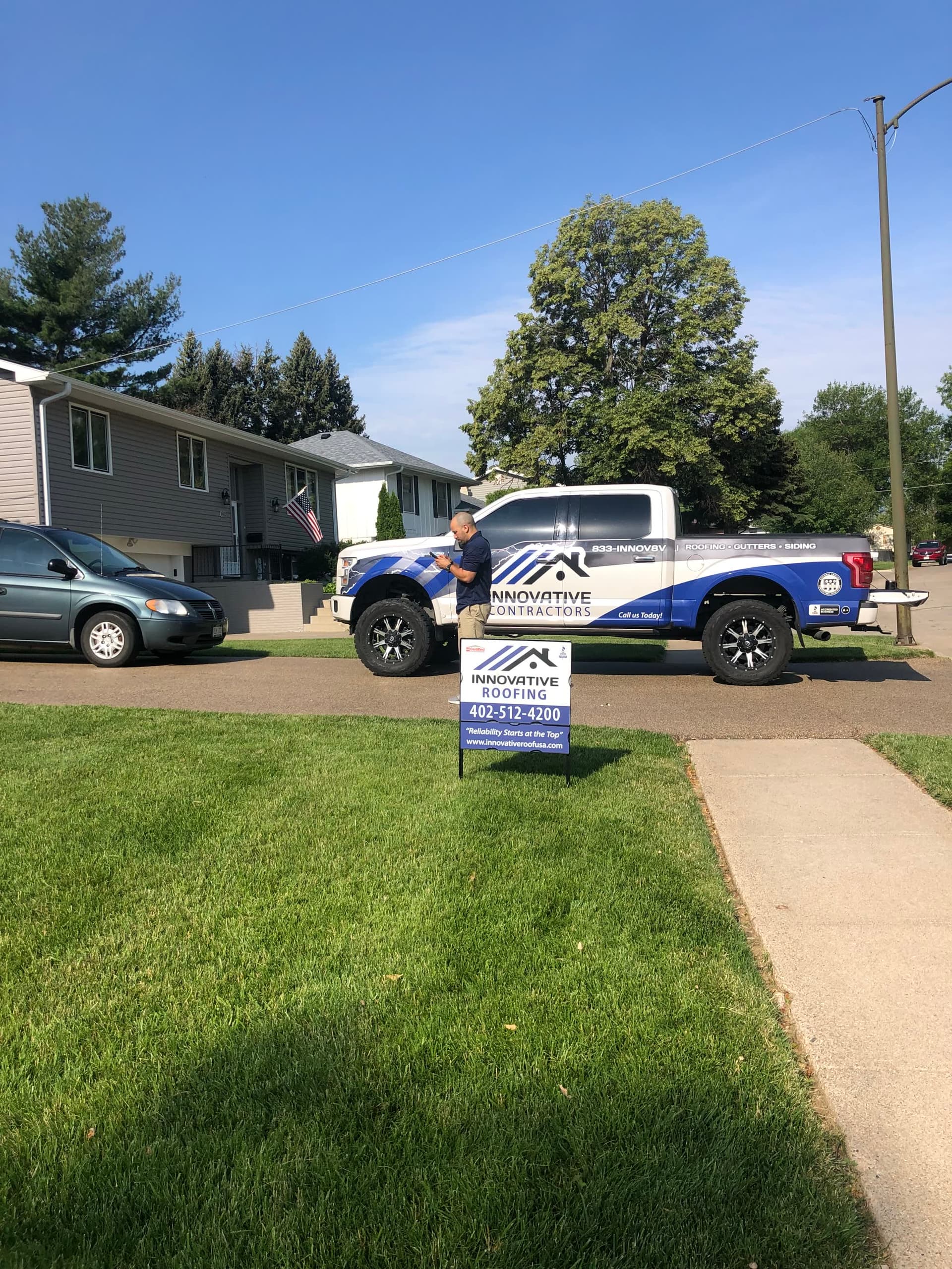 Innovative Roofing yard sign in the lawn with a wrapped company truck in the driveway