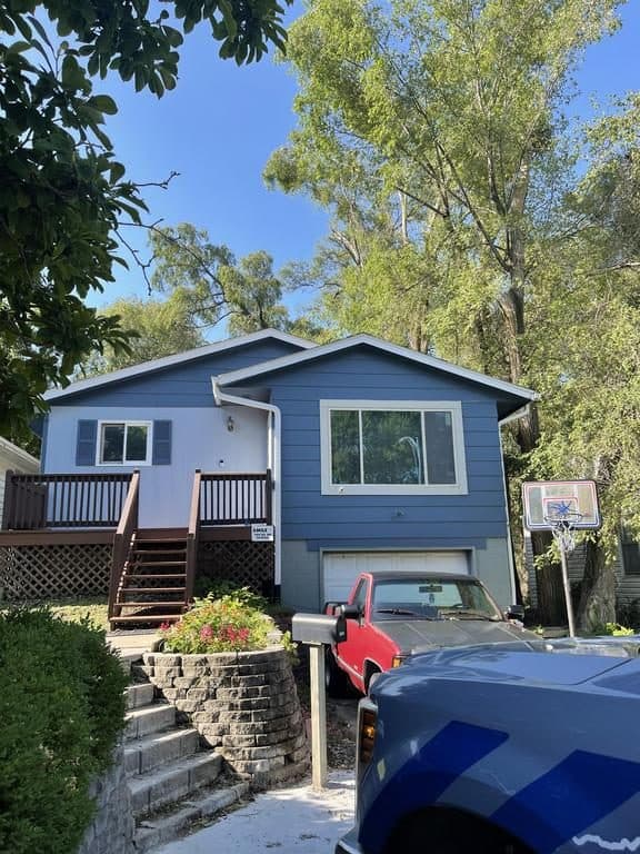 Two-story blue home with white trim and a finished brown shingle roof
