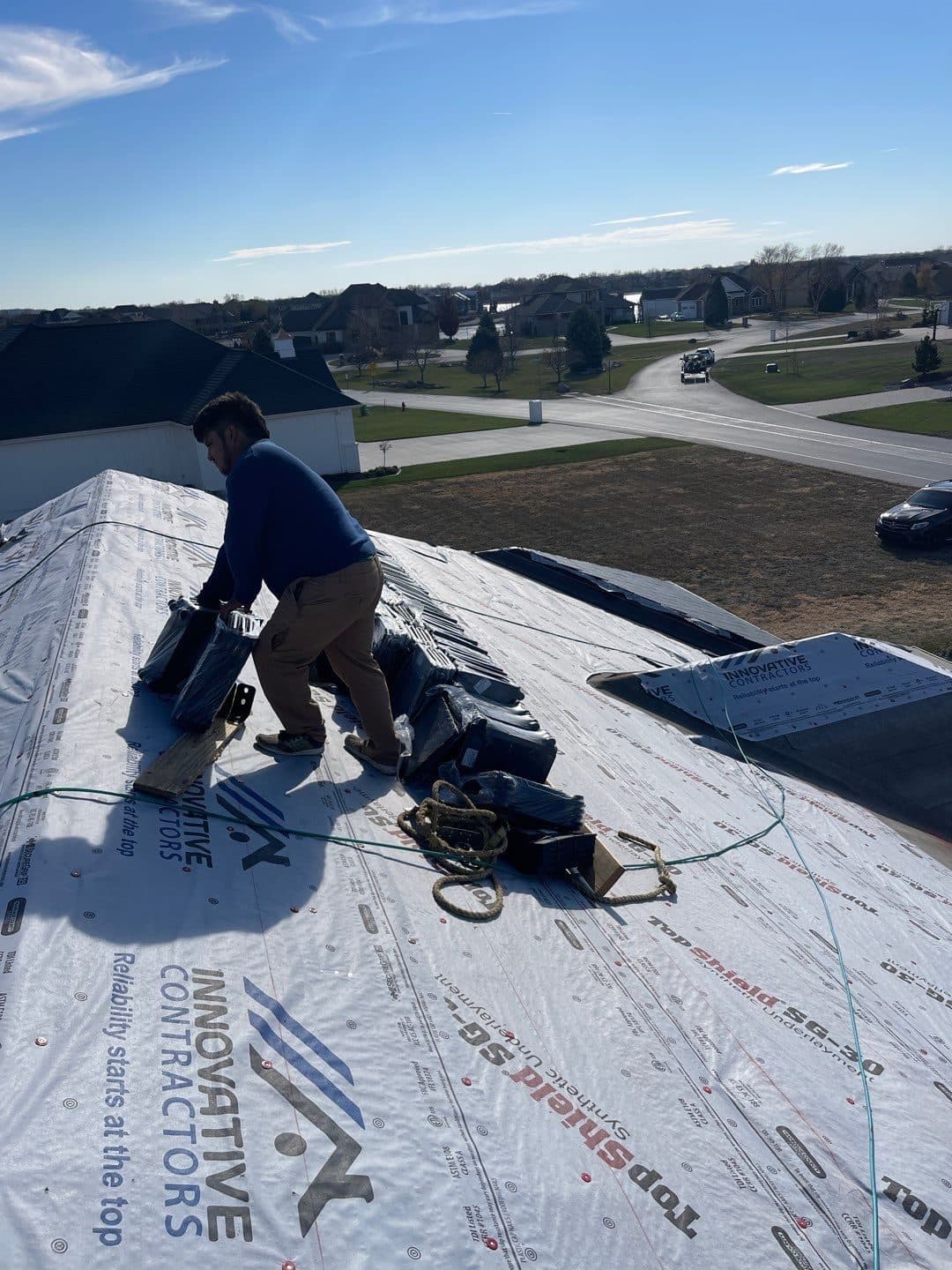 Roofer working on white Innovative Roofing branded underlayment