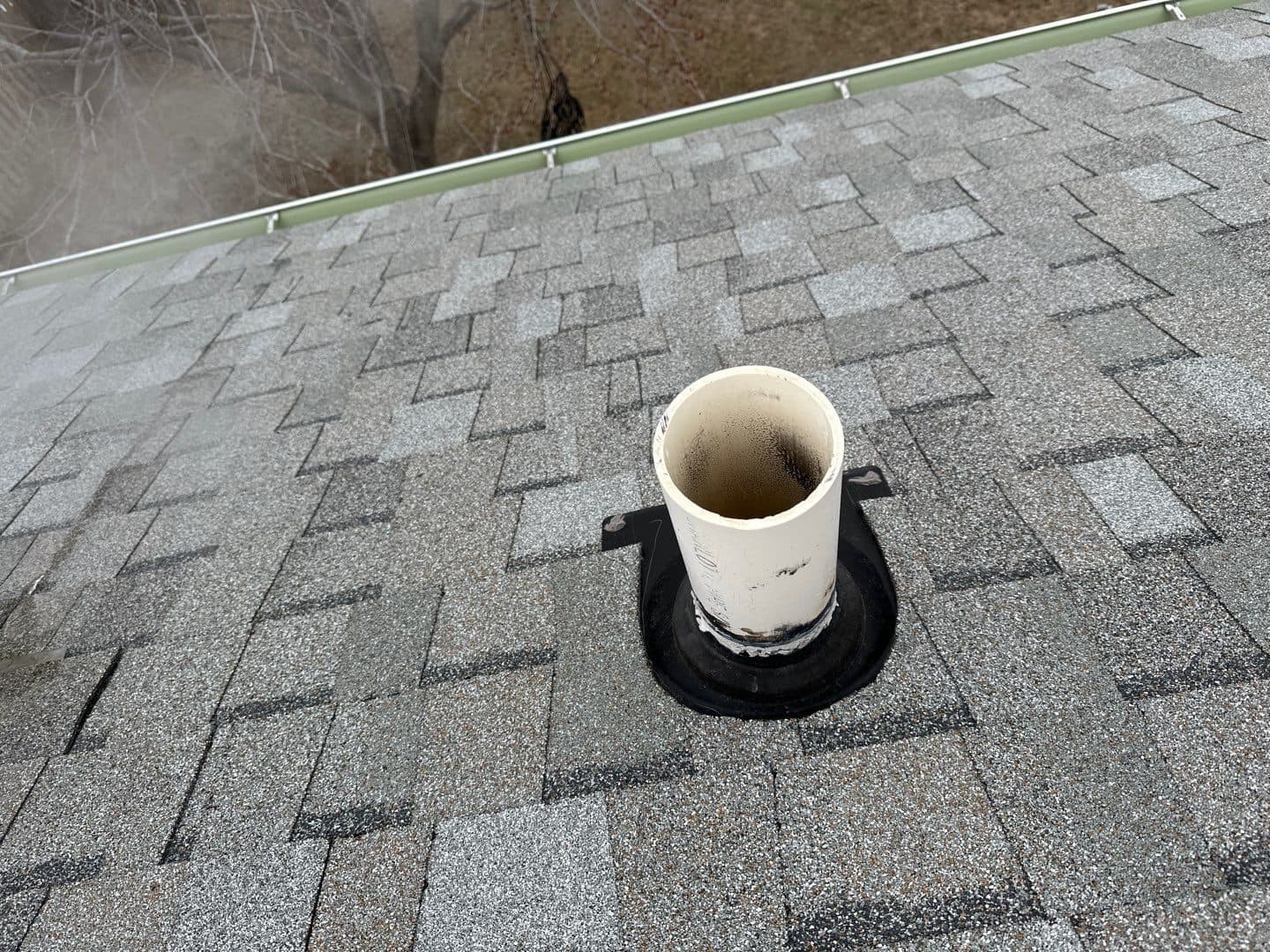 White pipe vent boot sealed into a new shingle roof