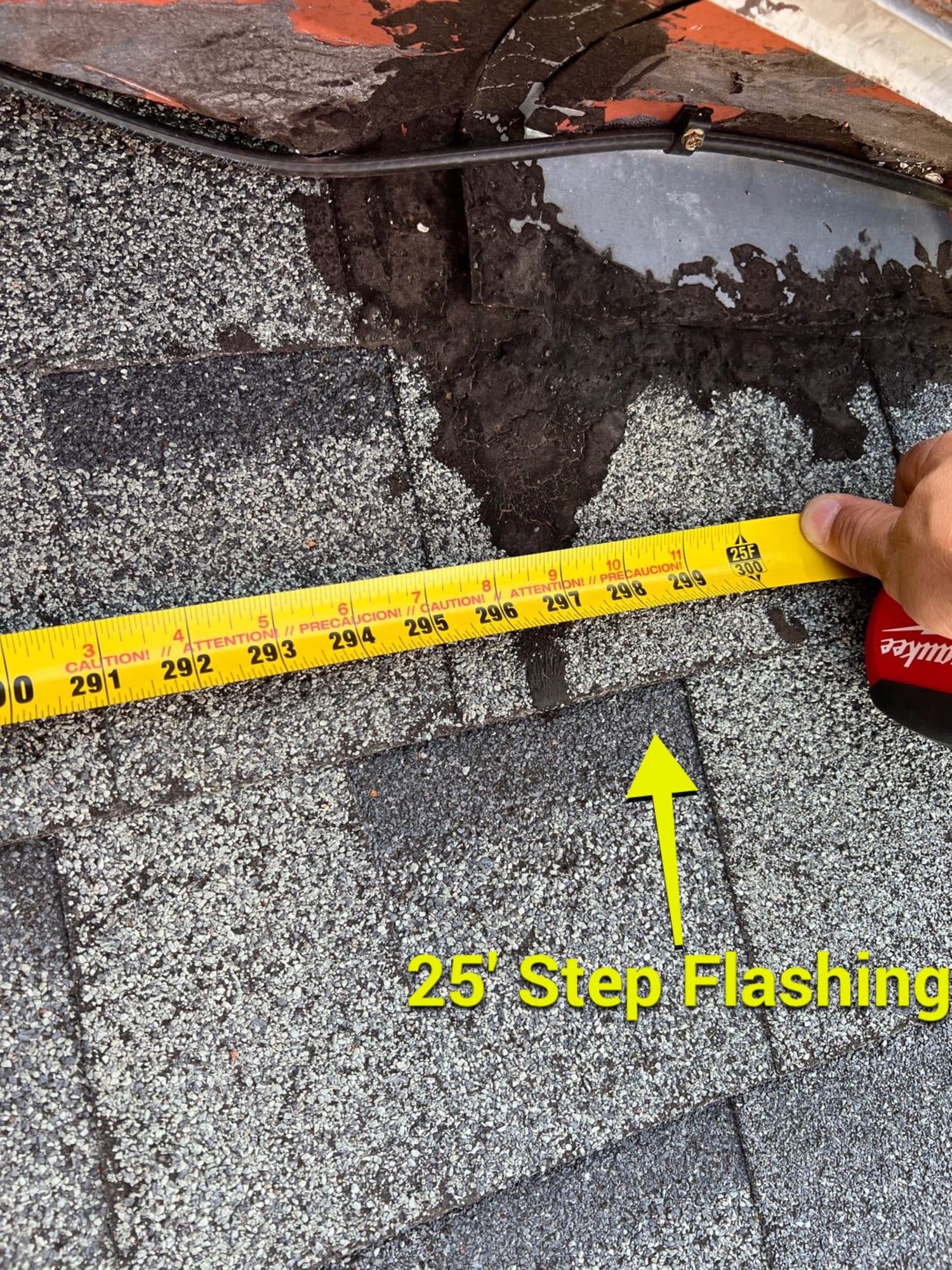 Close-up of step flashing measurement on a residential roof during repair