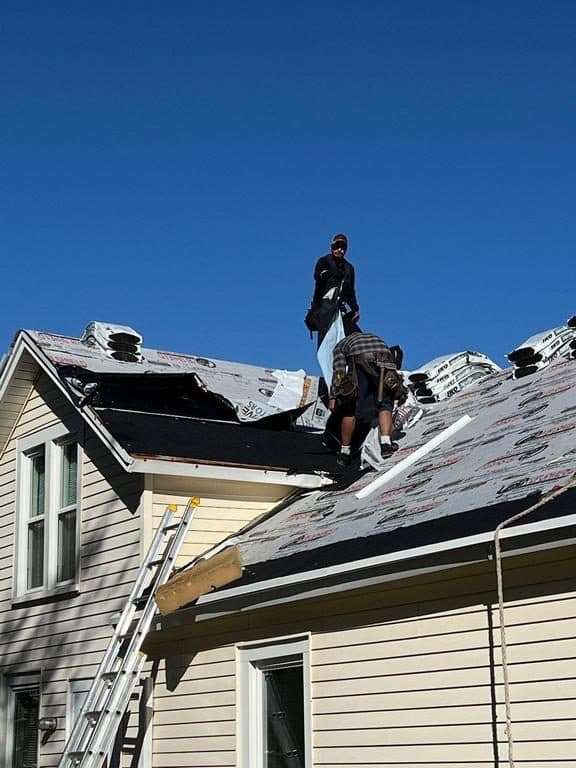 Residential home mid-replacement with two workers and exposed wood deck on one section
