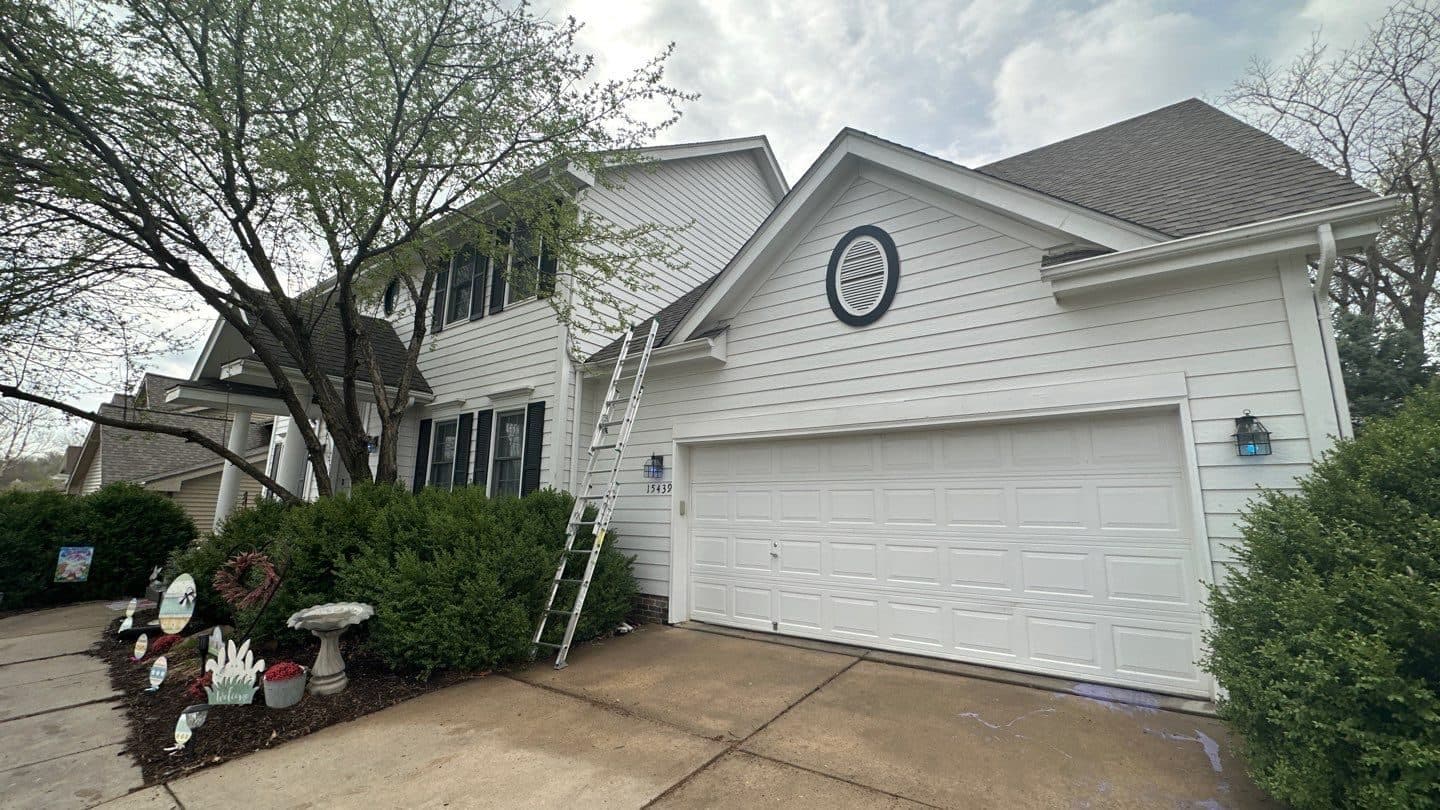 Front of a large two-story white home with a finished roof and garage