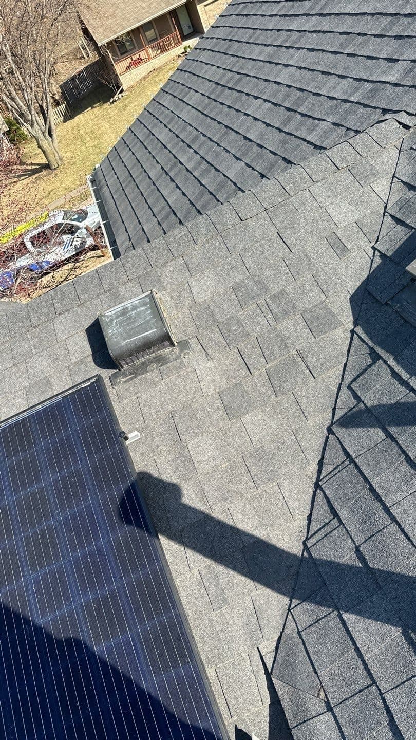 Finished gray shingle roof with a solar panel array on a residential home