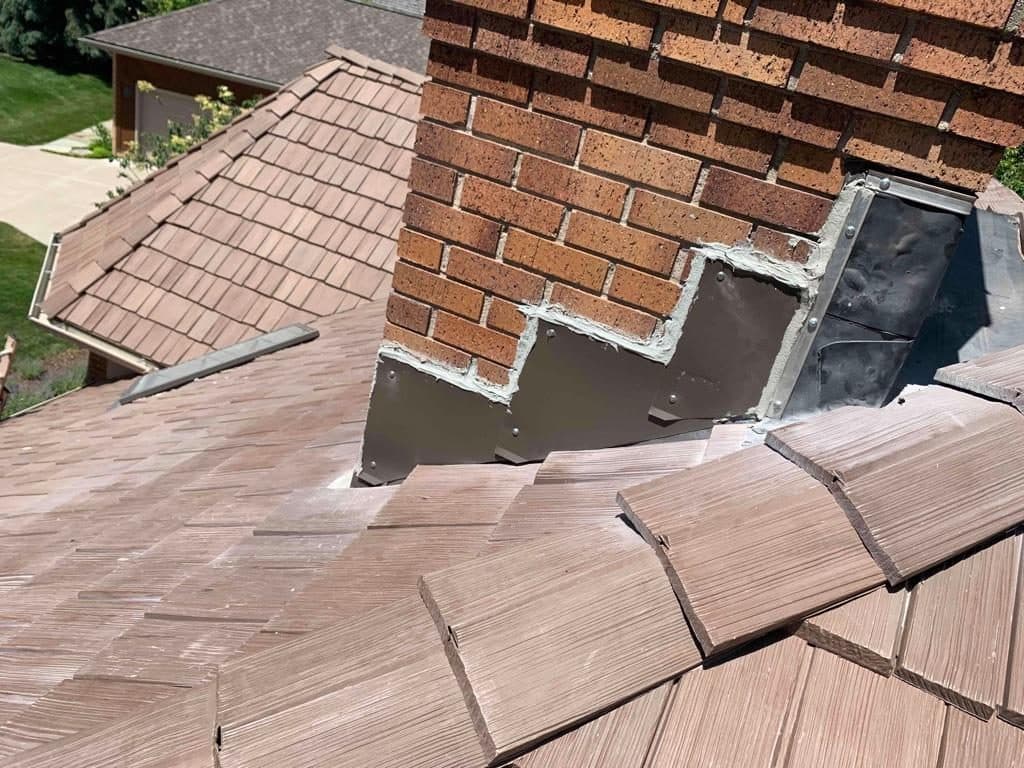 New metal chimney flashing where a tile roof meets brick